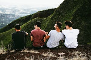 Four friends enjoying a scenic mountain view, symbolizing friendship and adventure.